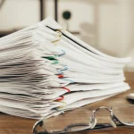Proposition de rectification : documents fiscaux sur un bureau, Maître Alexis Germe, avocat fiscaliste à Bordeaux